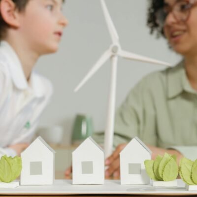 Children engage in learning about renewable energy with wind turbines and eco-friendly models in a classroom setting.