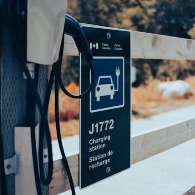 Electric vehicle charging station with scenic background and clear signage.