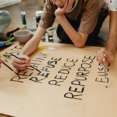 Kids creating a poster on recycling and environmental awareness in an educational setting.