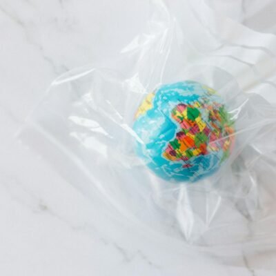 Mini globe encased in a plastic bag symbolizing environmental concerns about plastic waste.