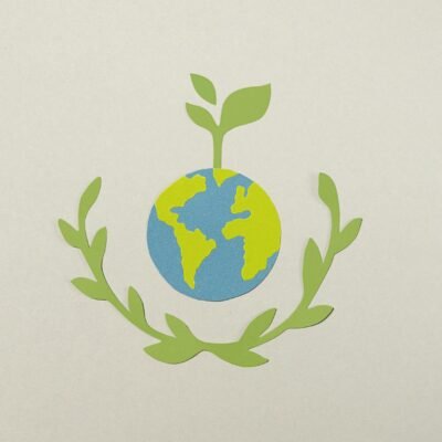 Paper cutout of Earth with plant symbolizing environmental conservation.