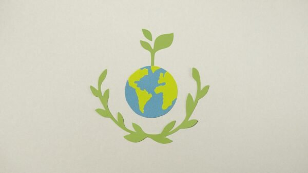 Paper cutout of Earth with plant symbolizing environmental conservation.